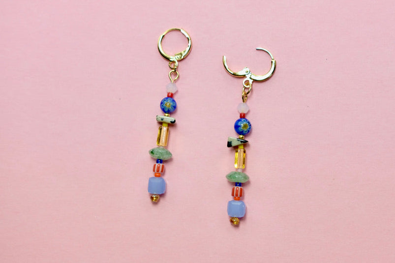 Pair of beaded earrings on a pink background