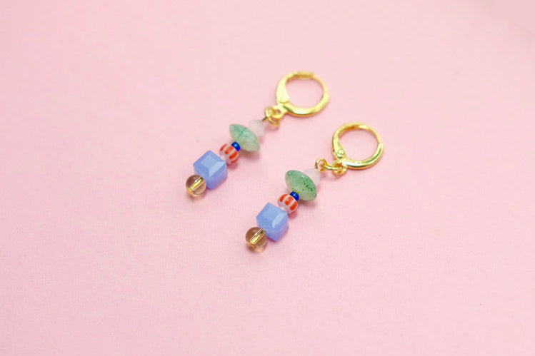 Pair of beaded earrings on a pink background