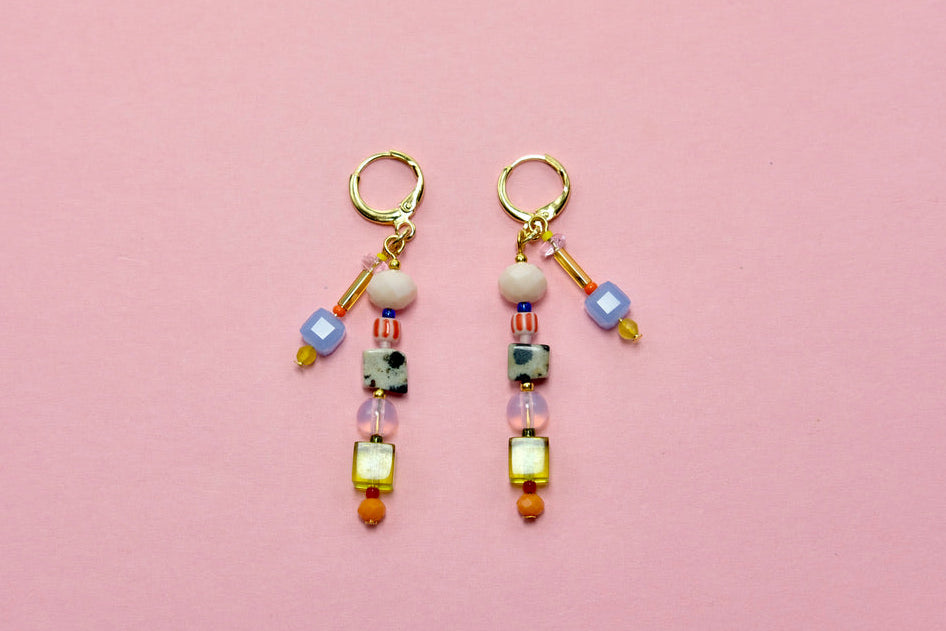Pair of beaded earrings on a pink background