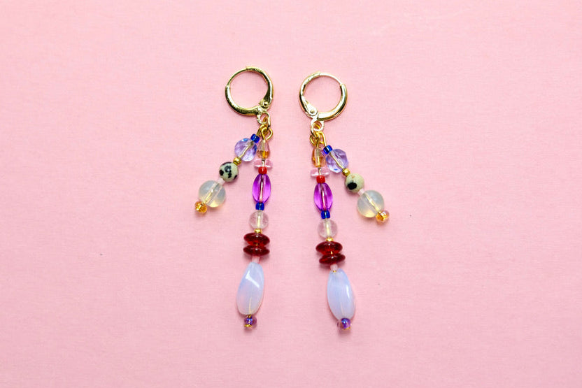 Pair of beaded earrings on a pink background
