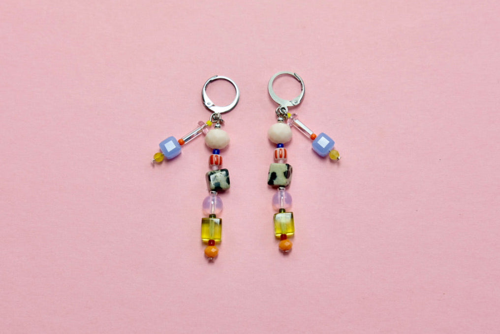 Pair of beaded earrings on a pink background