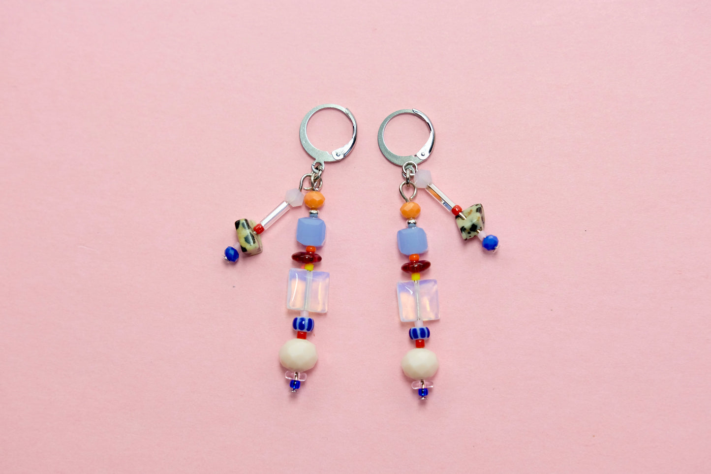 Pair of beaded earrings on a pink background