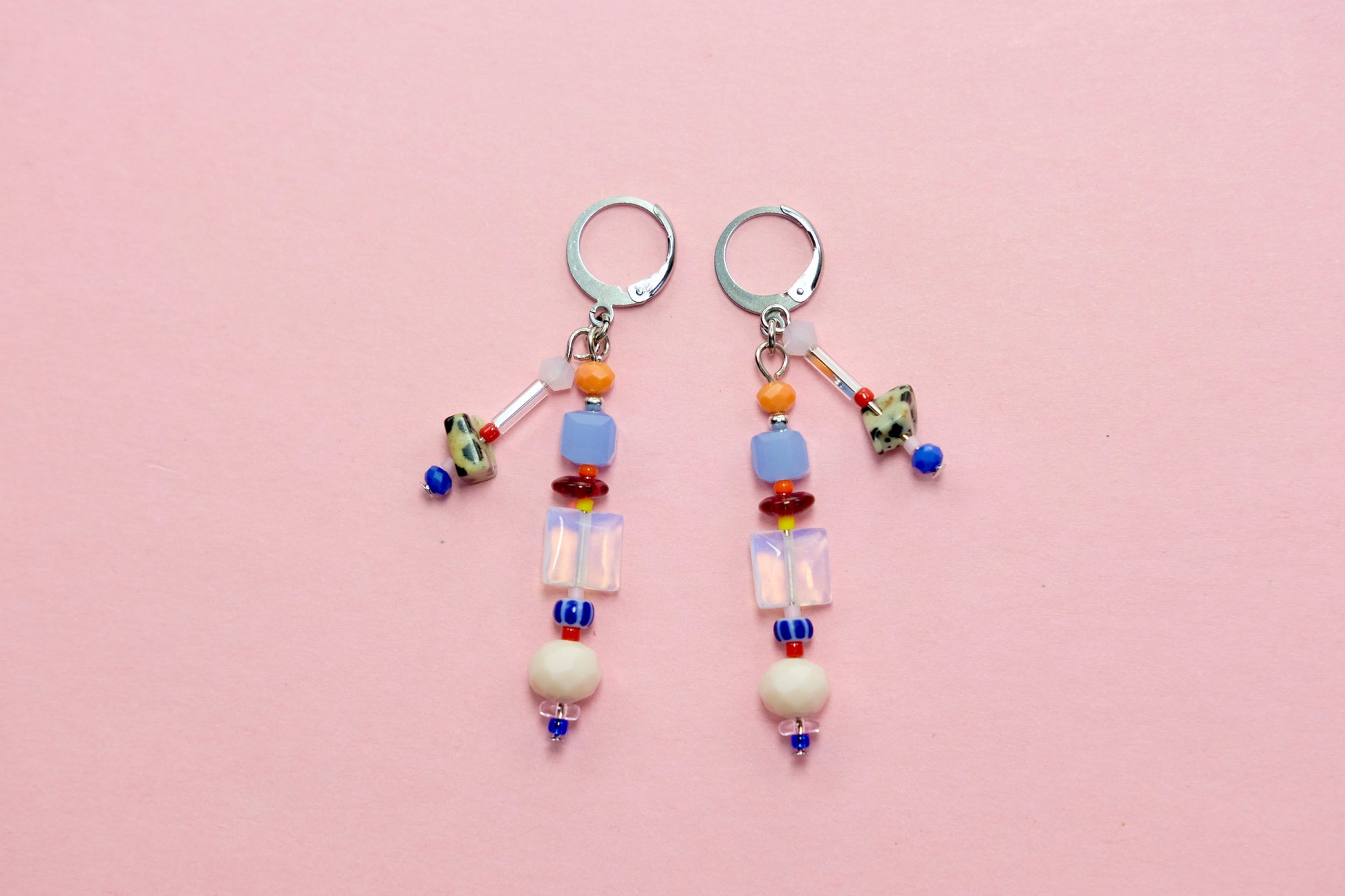 Pair of beaded earrings on a pink background