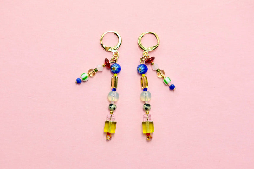 Pair of beaded earrings on a pink background