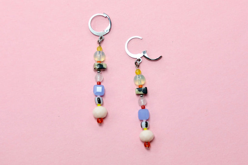 Pair of beaded earrings on a pink background
