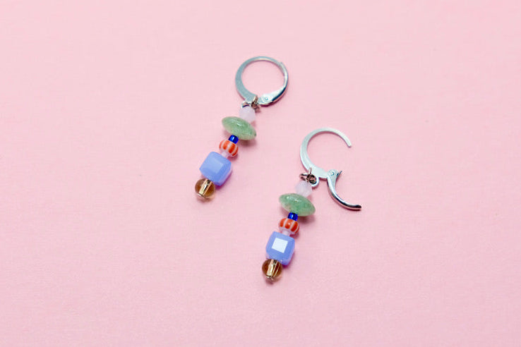 Pair of beaded earrings on a pink background