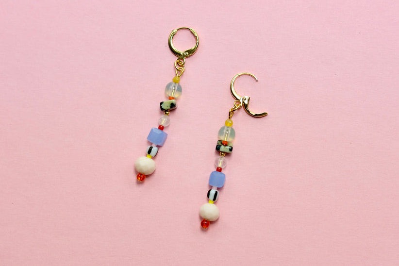 Pair of beaded earrings on a pink background