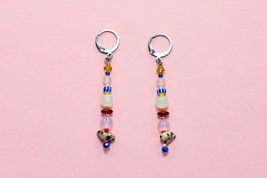 Pair of beaded earrings on a pink surface