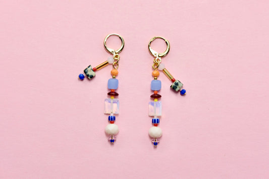 Pair of beaded earrings on a pink background