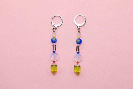 Two beaded earrings on a pink background