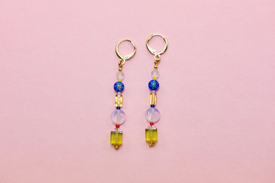 Pair of beaded earrings on a pink background