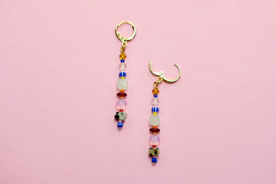 Pair of beaded earrings on a pink background