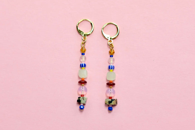Pair of beaded earrings on a pink background