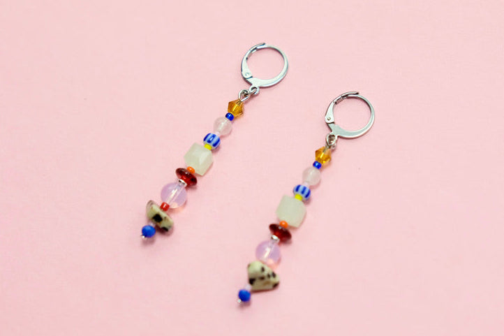 Pair of beaded earrings on a pink surface