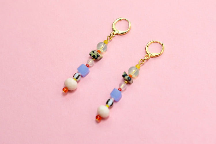 Pair of beaded earrings on a pink background