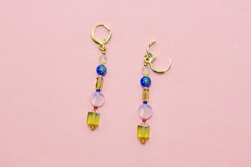 Pair of beaded earrings on a pink background