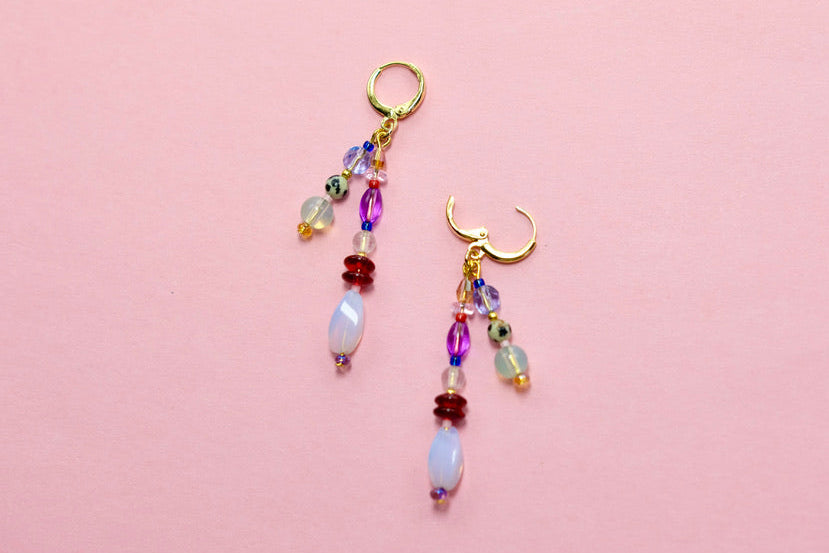 Pair of beaded earrings on a pink background