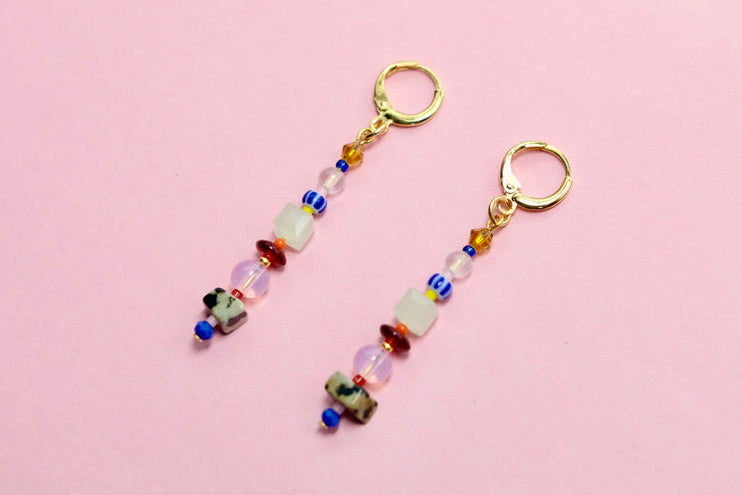 Pair of beaded earrings on a pink background