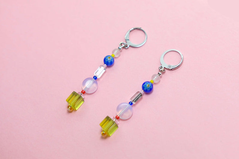 Pair of beaded earrings on a pink surface