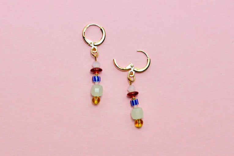 Pair of beaded earrings on a pink background