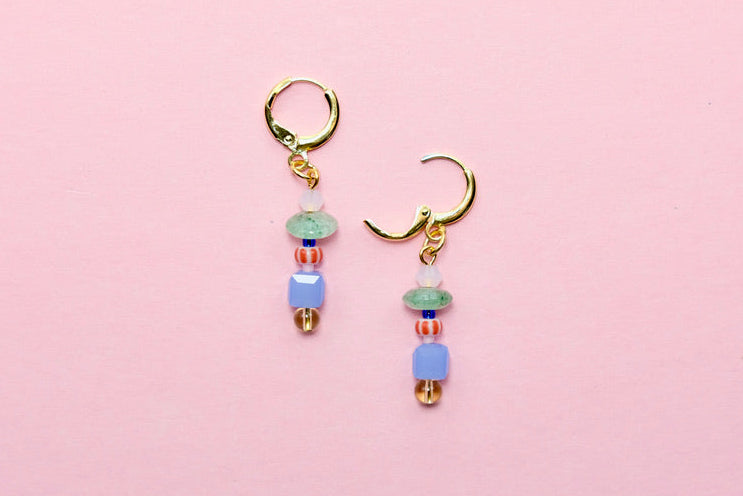 Pair of beaded earrings on a pink background