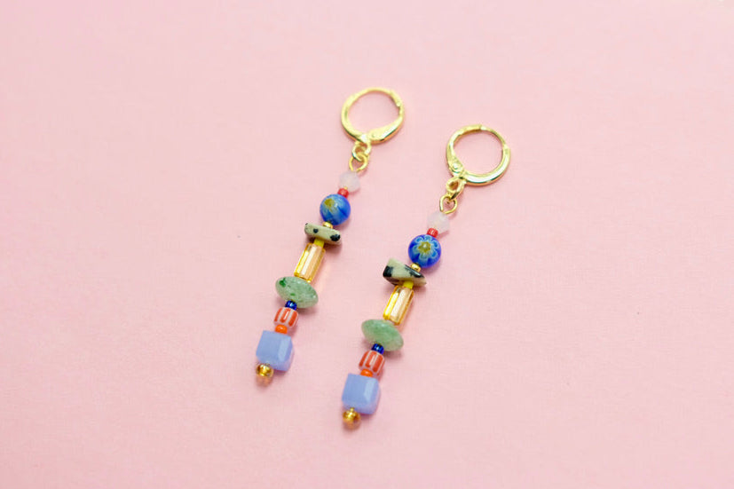 Pair of beaded earrings on a pink background