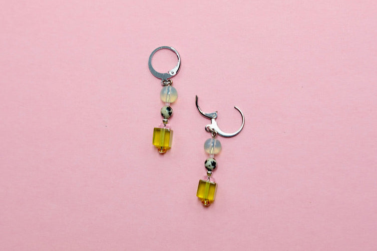 Pair of earrings with lime beads on a pink background