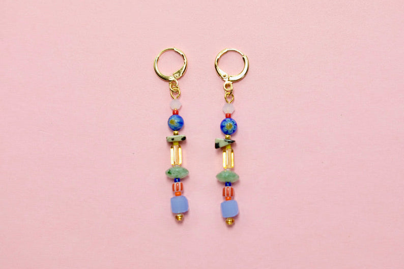 Pair of beaded earrings on a pink background