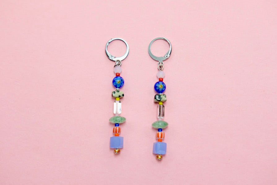 Pair of beaded earrings on a pink background