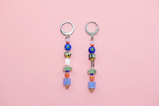 Pair of beaded earrings on a pink background