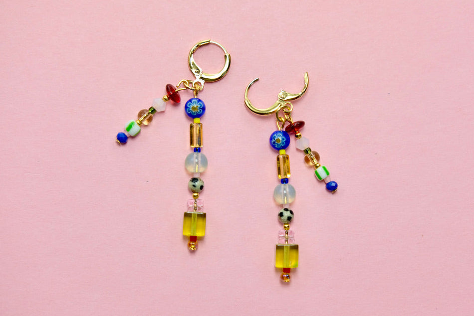 Pair of beaded earrings on a pink background