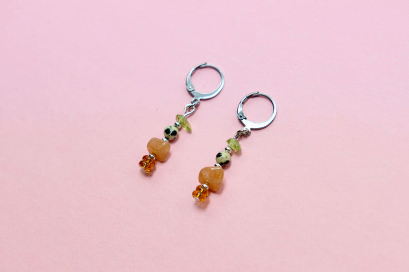 Pair of beaded earrings on a pink background