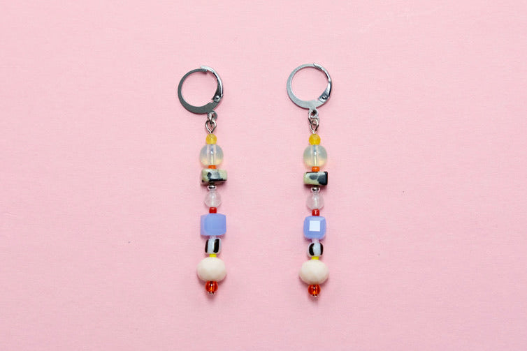 Pair of beaded earrings on a pink background