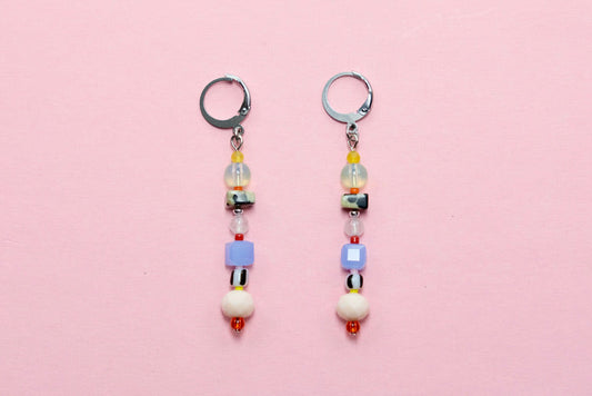 Pair of beaded earrings on a pink background