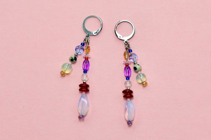 Pair of beaded earrings on a pink surface 