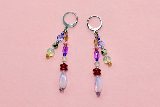 Pair of beaded earrings on a pink surface 